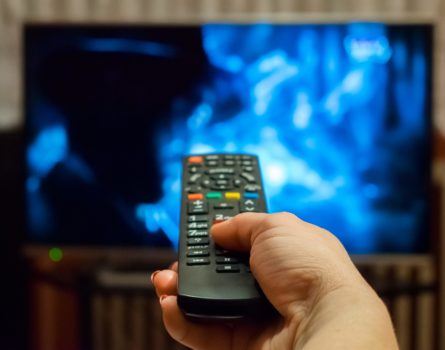 holding a remote towards a tv