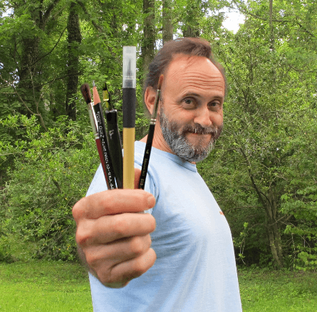 Illustrator Art Hondros holding up paint brushes