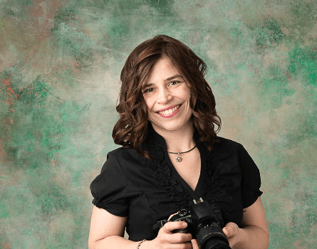 Headshot of Photographer Betsy Finn holding a camera