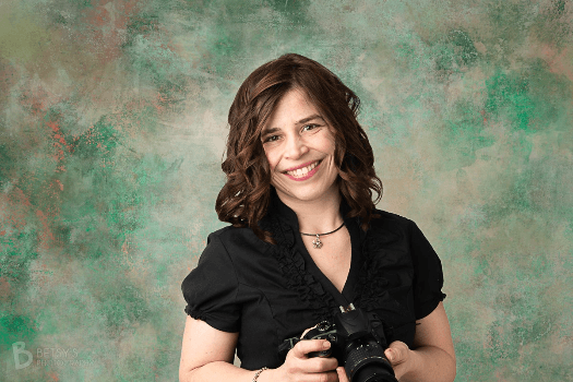 Headshot of Photographer Betsy Finn holding a camera